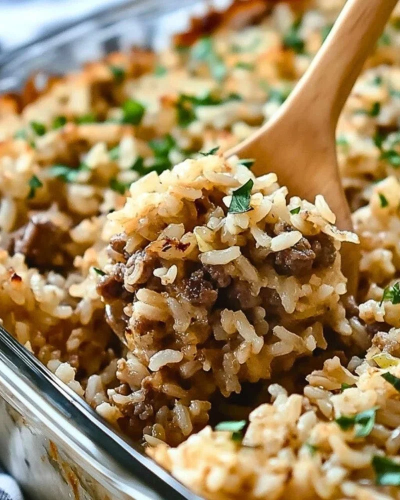A serving of French onion beef rice casserole with ground beef and rice topped with herbs.